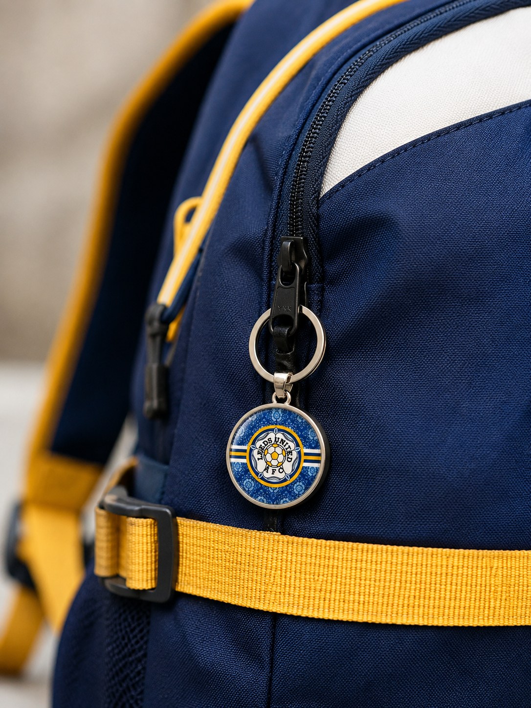 Blue Leeds rose keyring clipped to a blue, white and yellow backpack.