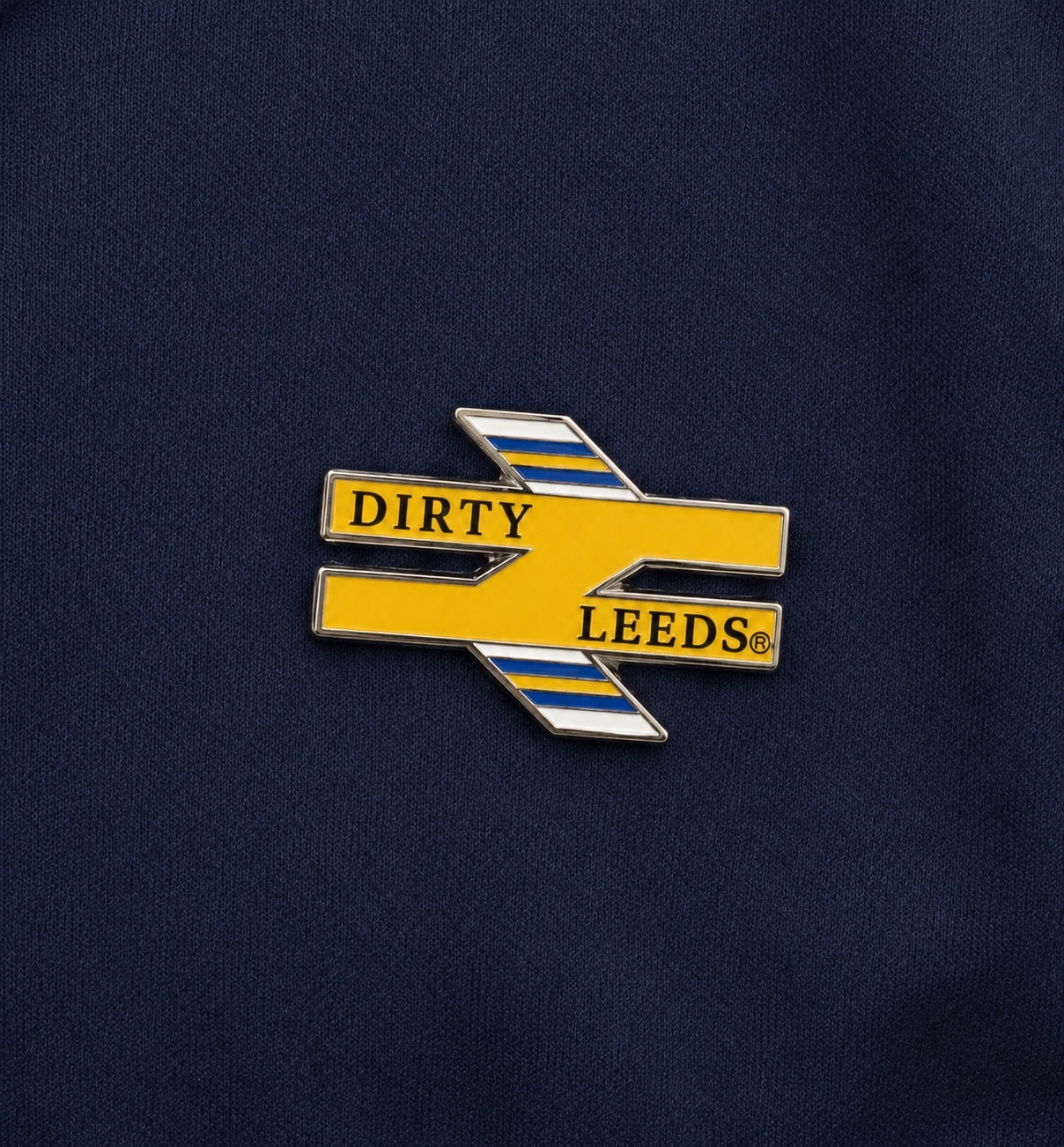 Dirty Leeds Trainlines enamel pin badge close-up on navy fabric.