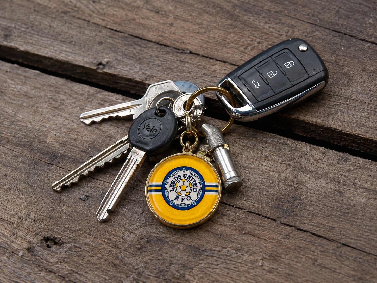 Yellow Leeds rose badge keyring on a set of house and car keys.
