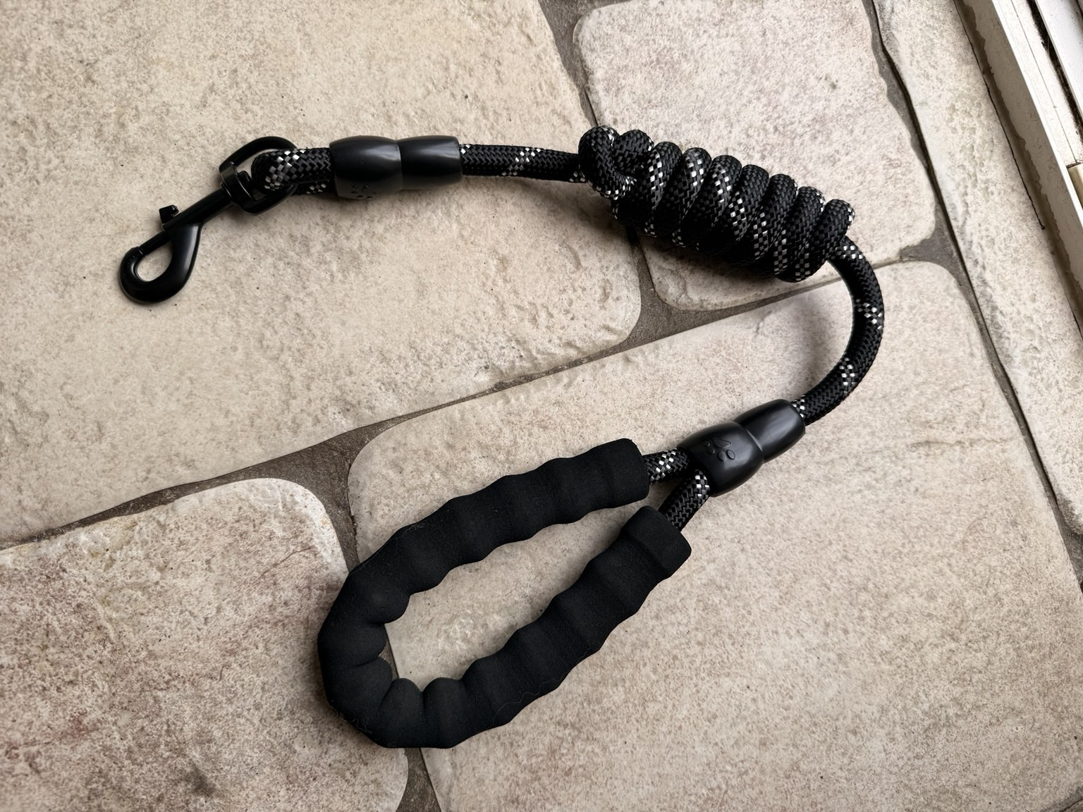 The supplied one-metre black rope lead with padded handle and metal clasp.